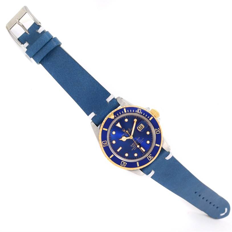 The Rolex Submariner 16803 Men
s Steel and Gold (two tone) Blue Dial 16803 Men
s Steel and Gold (two tone) Blue Dial watch is shown at an angled top view, displaying the blue dial, bezel, case, and blue strap.