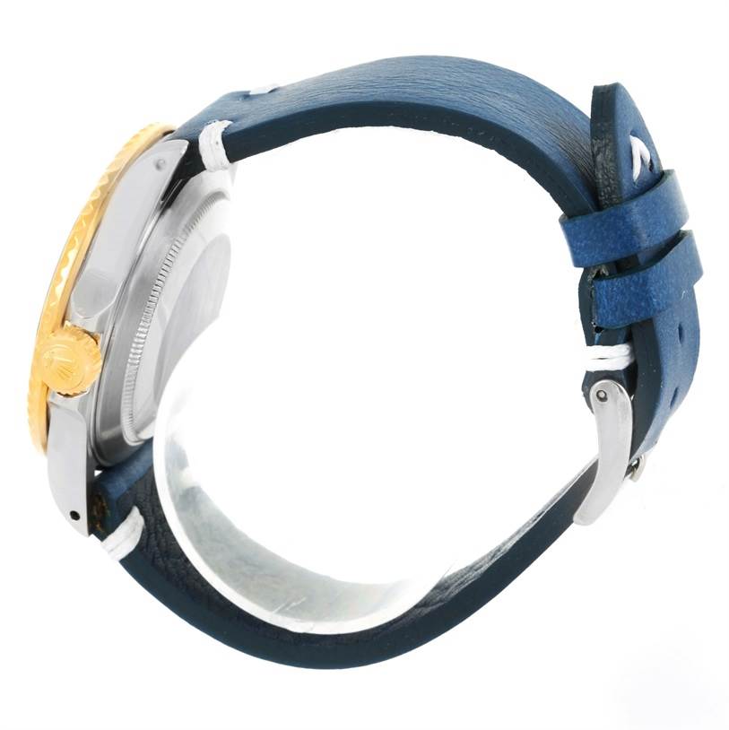 The Rolex Submariner 16803 Men
s Steel and Gold (two tone) Blue Dial 16803 Men
s Steel and Gold (two tone) Blue Dial watch is shown from a side angle, highlighting its crown, bezel, and blue leather strap.
