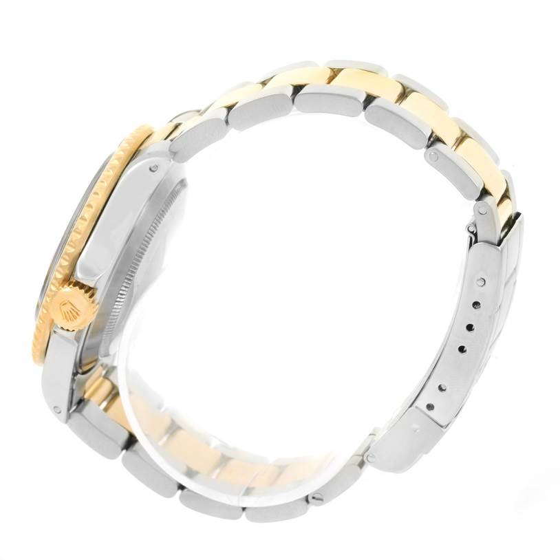 This side view of the Rolex Submariner 16613 Men
s Steel and Gold (two tone) Blue Dial 16613 Men
s Steel and Gold (two tone) Blue Dial shows the crown and two-tone bracelet, featuring both gold and stainless steel elements.