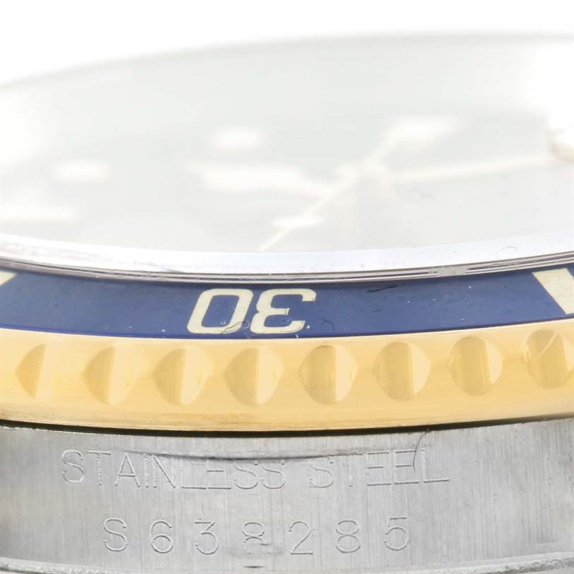 This close-up image of the Rolex Submariner 16613 Men
s Steel and Gold (two tone) Blue Dial 16613 Men
s Steel and Gold (two tone) Blue Dial shows the watch bezel, edge of the dial, and engraved stainless steel case with model details.