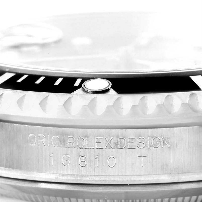 Close-up view of a Rolex Submariner 16610 Men
s Stainless Steel Black Dial 16610 Men
s Stainless Steel Black Dial, showing the bezel, crystal, parts of the dial, and engraved case with model number.
