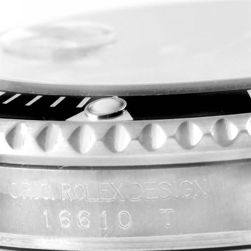 The image shows a close-up side view of a Rolex Submariner 16610 Men
s Stainless Steel Black Dial 16610 Men
s Stainless Steel Black Dial model, highlighting the bezel, part of the dial, and engraved reference number 16610.