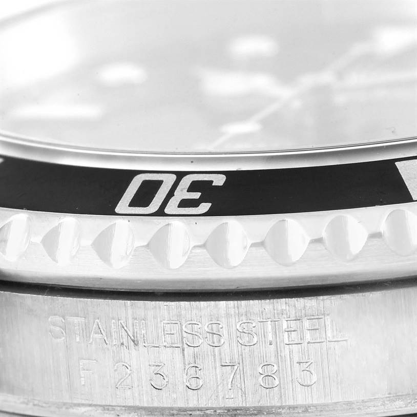 This close-up shows the bezel, case, and part of the serial number of a Rolex Submariner 16610 Men
s Stainless Steel Black Dial 16610 Men
s Stainless Steel Black Dial watch.