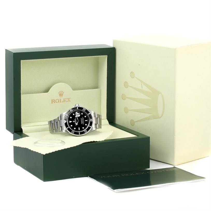 The Rolex Submariner 16610 Men
s Stainless Steel Black Dial 16610 Men
s Stainless Steel Black Dial watch is displayed inside its open box with paperwork and packaging visible.