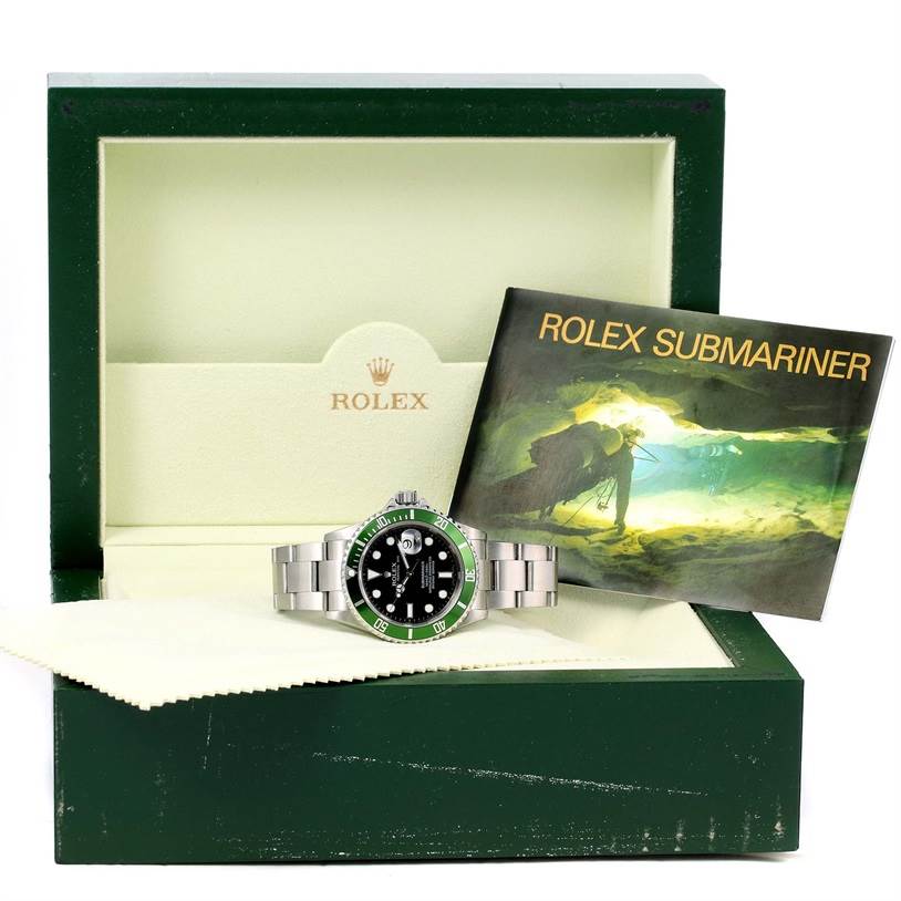 The image shows a Rolex Submariner 16610LV Men
s Stainless Steel Black Dial 16610LV Men
s Stainless Steel Black Dial watch, its box, and a booklet partially inside the box.
