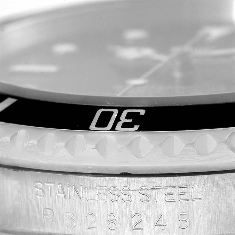This close-up image of a Rolex Submariner 168000 Men
s Stainless Steel Black Dial 168000 Men
s Stainless Steel Black Dial shows the bezel, part of the dial, and the engraved case side.
