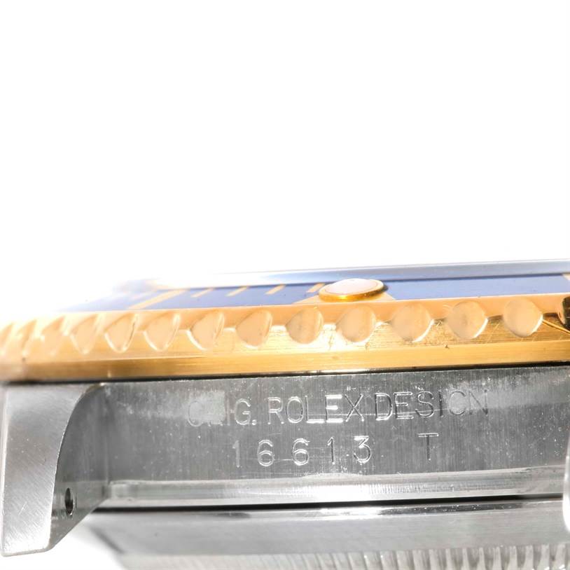 The image shows a side view of the bezel, case, and model engraving on a Rolex Submariner 16613 Men
s Steel and Gold (two tone) Blue Dial 16613 Men
s Steel and Gold (two tone) Blue Dial watch.