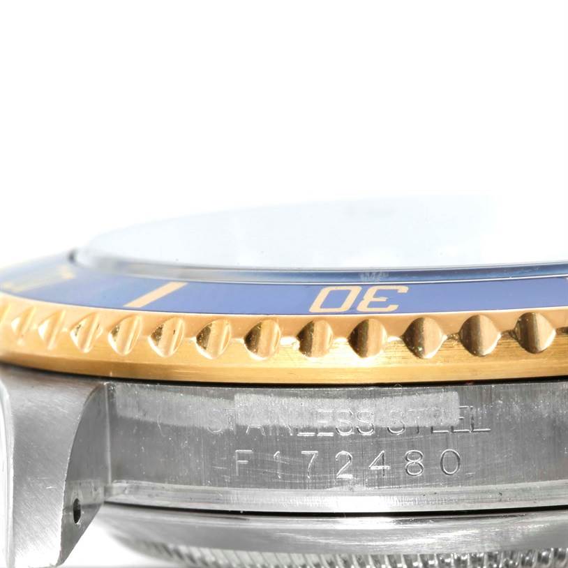 The image shows a close-up side view of the bezel, crystal, and part of the stainless steel case of a Rolex Submariner 16613 Men
s Steel and Gold (two tone) Blue Dial 16613 Men
s Steel and Gold (two tone) Blue Dial watch.