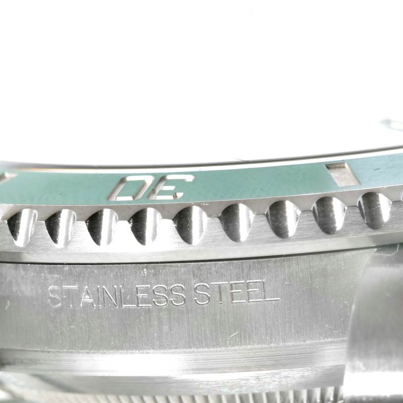 This close-up image shows the bezel and part of the casing with "STAINLESS STEEL" engraved on a Rolex Submariner 116610LV Men
s Stainless Steel Green Dial 116610LV Men
s Stainless Steel Green Dial watch.