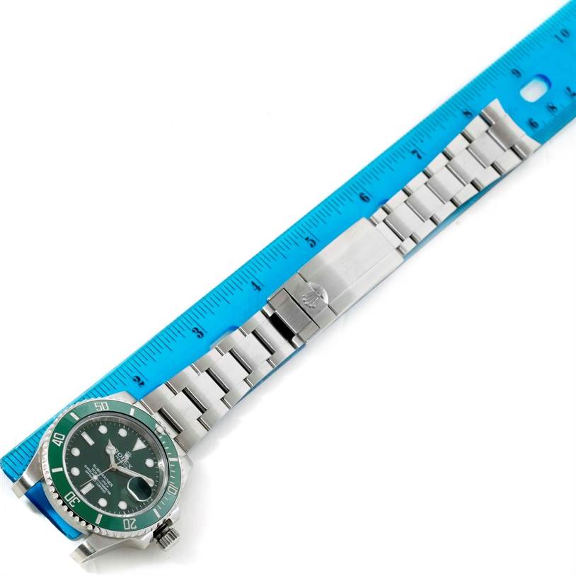 The image shows the Rolex Submariner 116610LV Men
s Stainless Steel Green Dial 116610LV Men
s Stainless Steel Green Dial watch with a green bezel and stainless steel bracelet, placed beside a ruler for measurement.