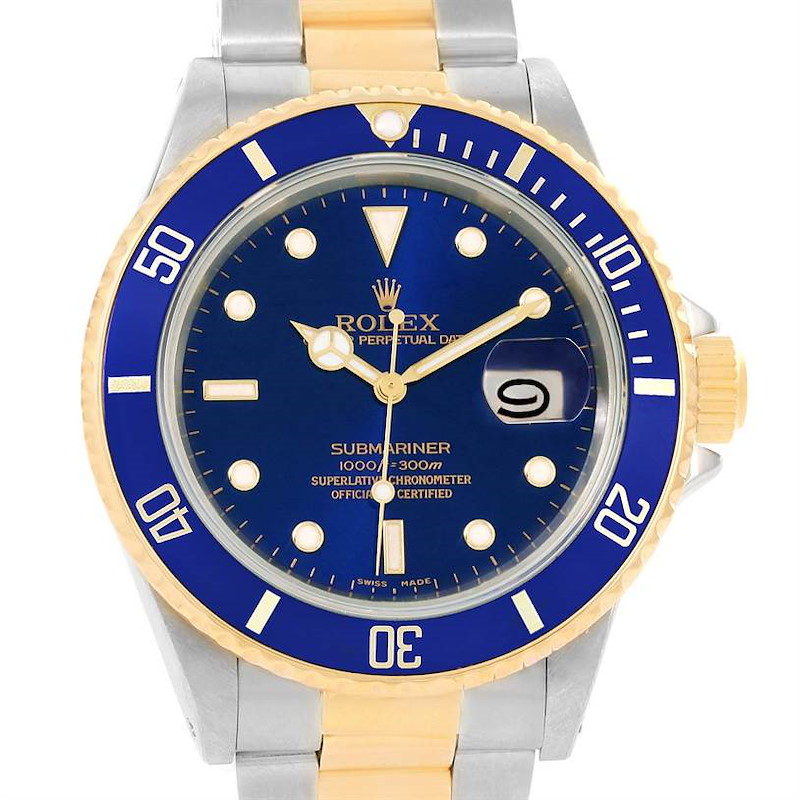 This image shows the face and part of the bracelet of a Rolex Submariner watch, featuring a blue dial and bezel with gold accents.