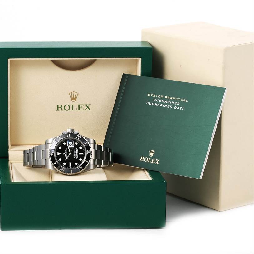 The Rolex Submariner 116610 Men
s Stainless Steel Black Dial 116610 Men
s Stainless Steel Black Dial watch is shown in its case alongside its user manual, viewed from the front.
