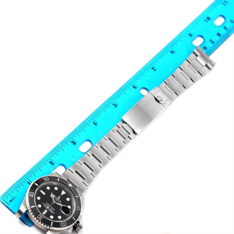 The image shows a Rolex Submariner 116610 Men
s Stainless Steel Black Dial 116610 Men
s Stainless Steel Black Dial watch laid flat with a ruler measuring its bracelet.