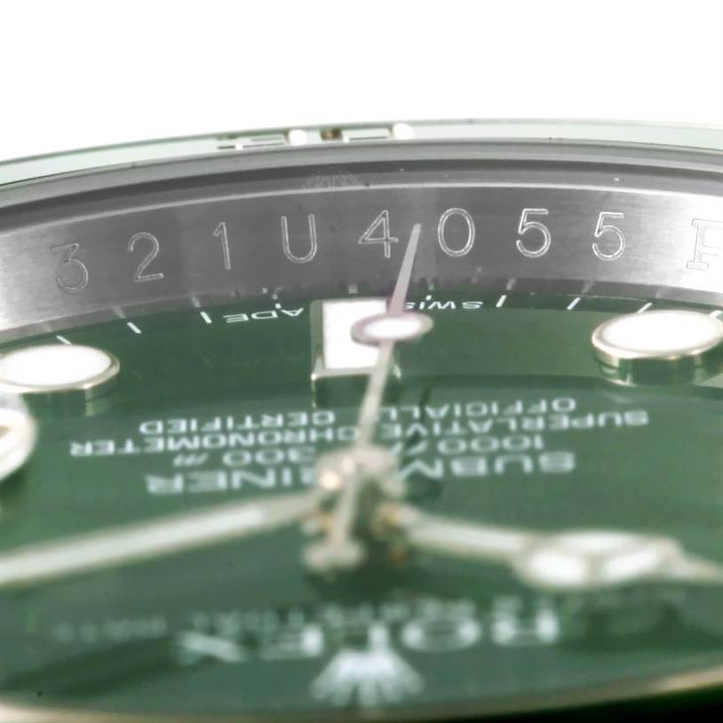 Close-up of the serial number engraving and partial face of a Rolex Submariner 116610LV Men's Stainless Steel Green Dial 116610LV Men's Stainless Steel Green Dial watch.