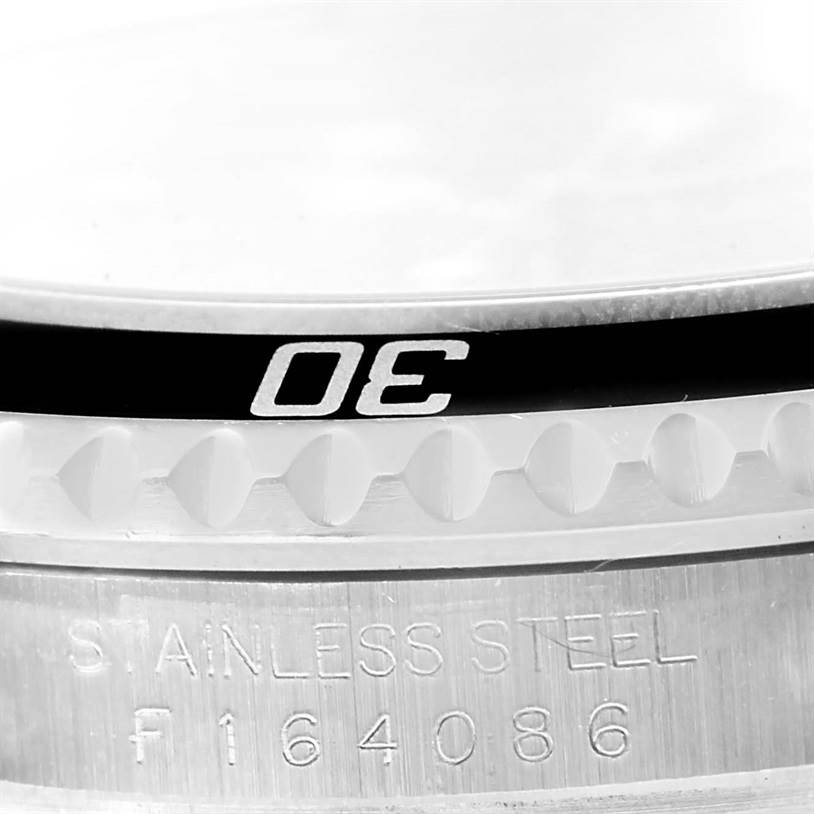 This image shows a close-up of the bezel and part of the stainless steel casing of a Rolex Submariner 16610 Men
s Stainless Steel Black Dial 16610 Men
s Stainless Steel Black Dial watch.