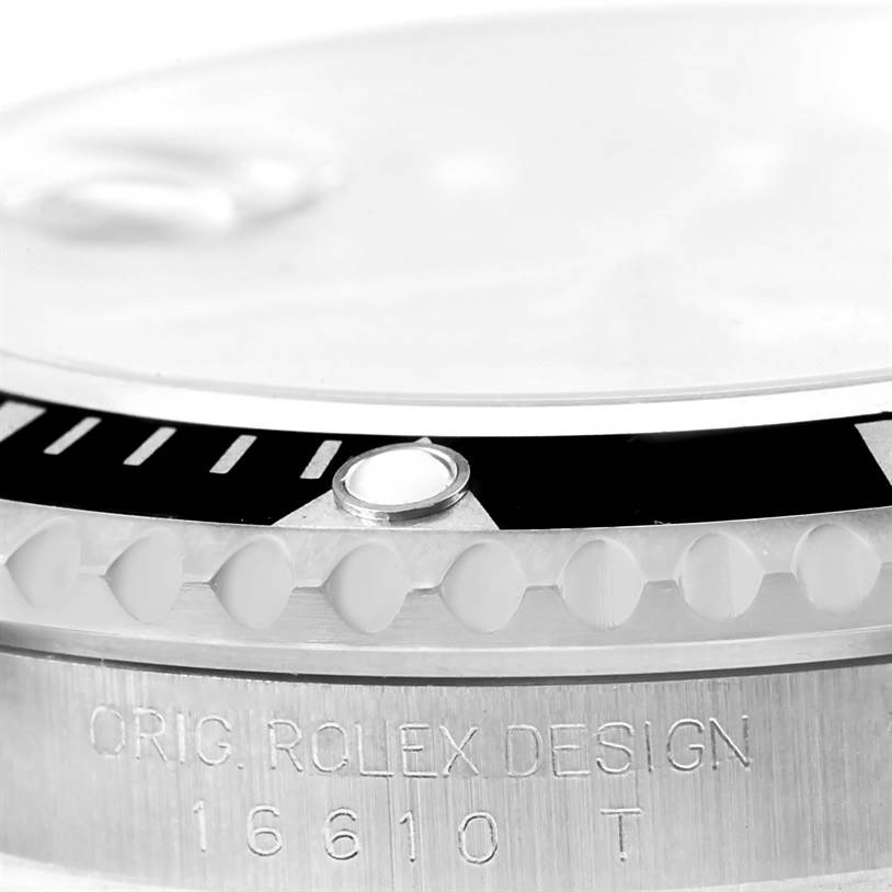 Close-up of a Rolex Submariner 16610 Men
s Stainless Steel Black Dial 16610 Men
s Stainless Steel Black Dial watch
s bezel, crystal, and engraved case showing the model number 16610.