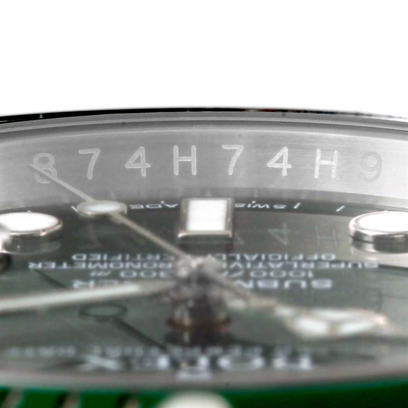 This close-up angle of the Rolex Submariner 116610LV Men's Stainless Steel Green Dial 116610LV Men's Stainless Steel Green Dial watch shows the serial number engraved at the inner bezel and partial watch dial.