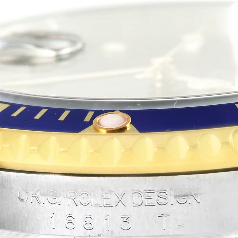 The image shows a close-up of the bezel and engraved case of the Rolex Submariner 16613 Men's Steel and Gold (two tone) Blue Dial 16613 Men's Steel and Gold (two tone) Blue Dial model 16613.