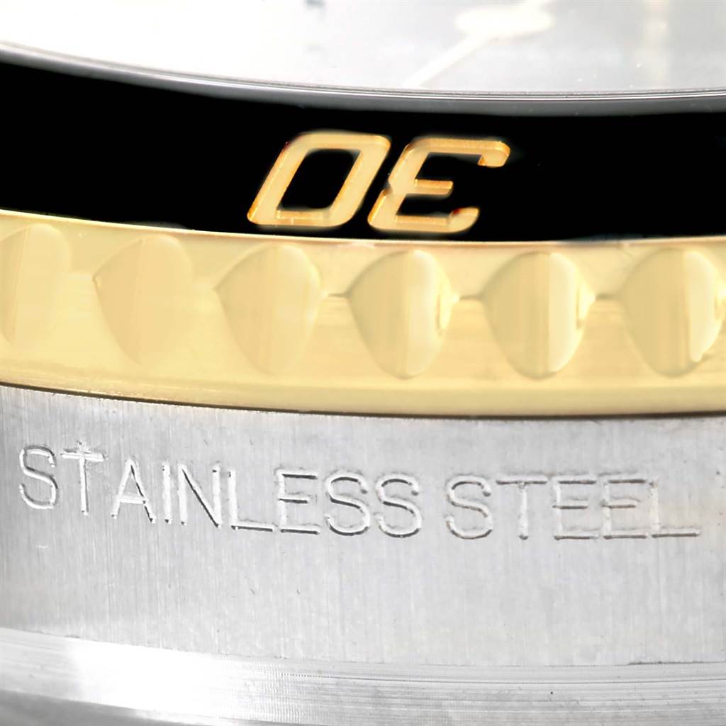 The image shows a close-up of the bezel and case of the Rolex Submariner 116613LN Men
s Steel and Gold (two tone) Black Dial 116613LN Men
s Steel and Gold (two tone) Black Dial watch, highlighting the "STAINLESS STEEL" engraving.