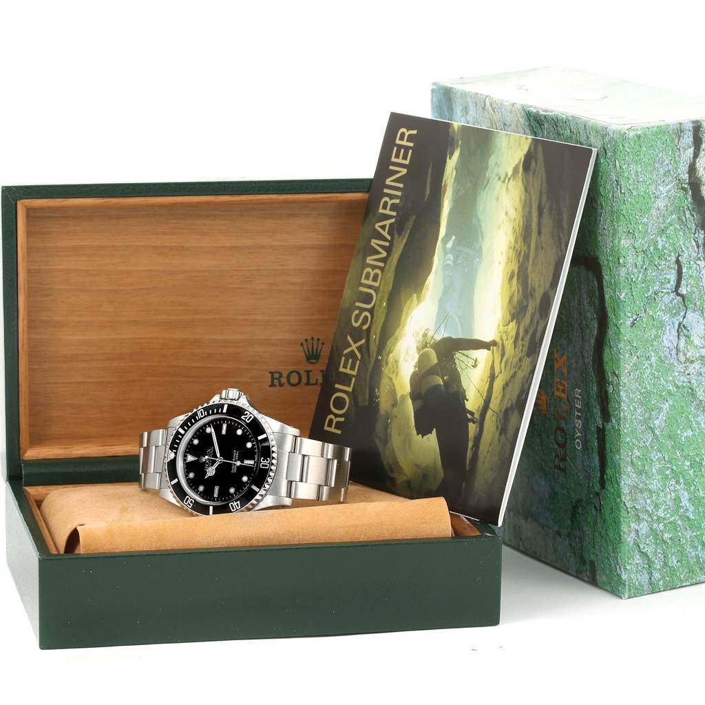 The image shows a Rolex Submariner 14060 Men
s Stainless Steel Black Dial 14060 Men
s Stainless Steel Black Dial watch with its box and user manual, angled slightly from the front.