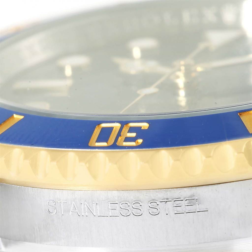 The image shows a close-up of the bezel and case of a Rolex Submariner 116613 Men
s Steel and Gold (two tone) Blue Dial 116613 Men
s Steel and Gold (two tone) Blue Dial, highlighting the blue and gold color.