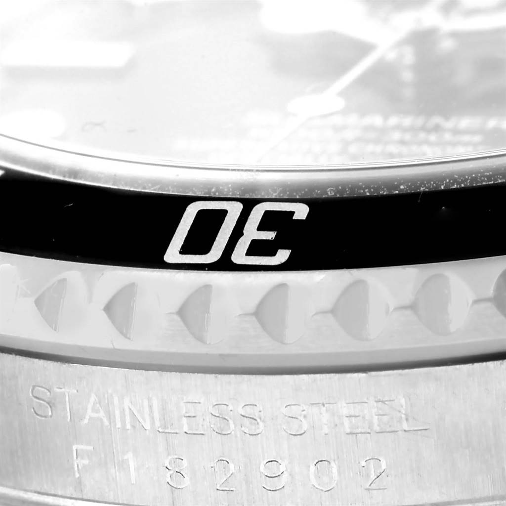 The image shows a close-up of the bezel and part of the textured edge of a Rolex Submariner 16610 Men
s Stainless Steel Black Dial 16610 Men
s Stainless Steel Black Dial watch, including the "STAINLESS STEEL" engraving.