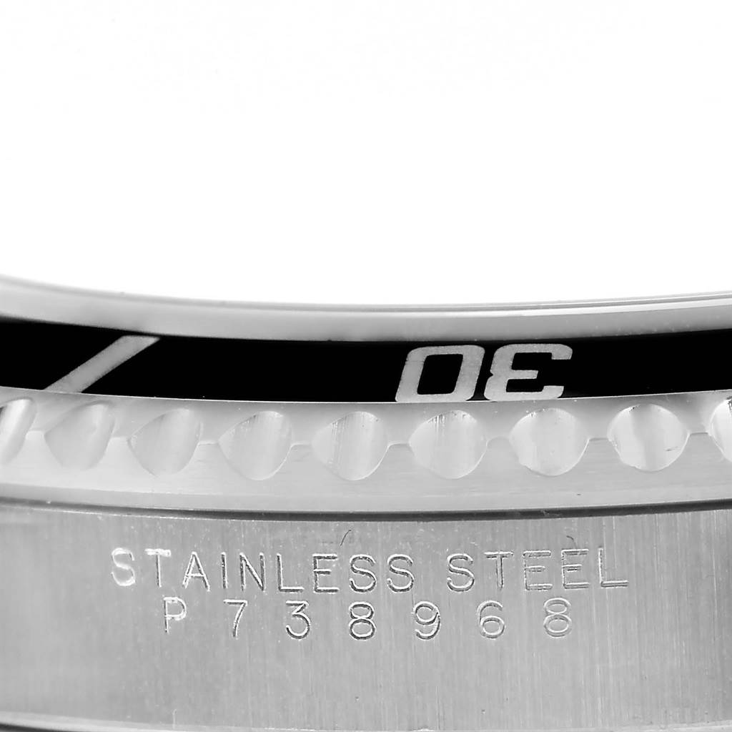 This close-up shows the bezel and case edge of a Rolex Submariner 14060 Men
s Stainless Steel Black Dial 14060 Men
s Stainless Steel Black Dial watch, with "STAINLESS STEEL" and a serial number engraved.