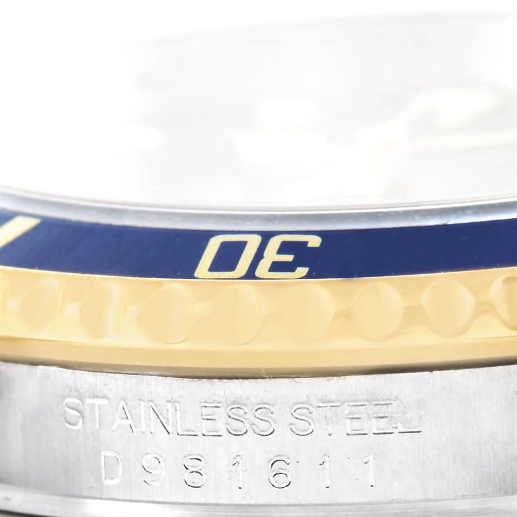 This close-up of the Rolex Submariner 16613 Men
s Steel and Gold (two tone) Blue Dial 16613 Men
s Steel and Gold (two tone) Blue Dial watch shows part of the bezel, case, and engraved serial number.