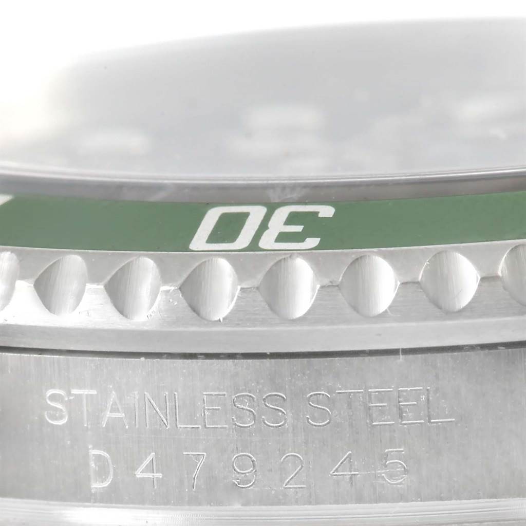 The image shows a close-up of the bezel and case side of a Rolex Submariner 16610LV Men
s Stainless Steel Black Dial 16610LV Men
s Stainless Steel Black Dial with visible serial and material inscriptions.