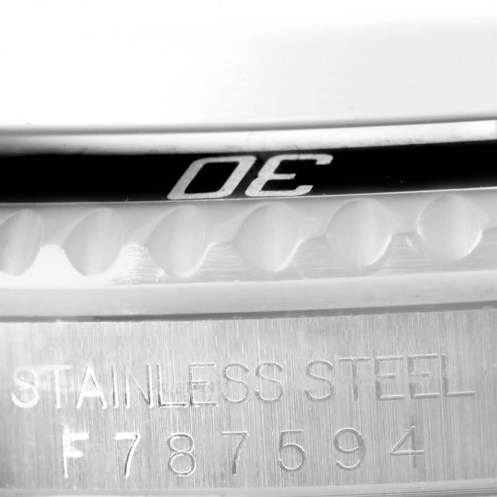 This close-up image shows the bezel and part of the case of a Rolex Submariner 16610 Men
s Stainless Steel Black Dial 16610 Men
s Stainless Steel Black Dial watch, highlighting the "STAINLESS STEEL" engraving and serial number.