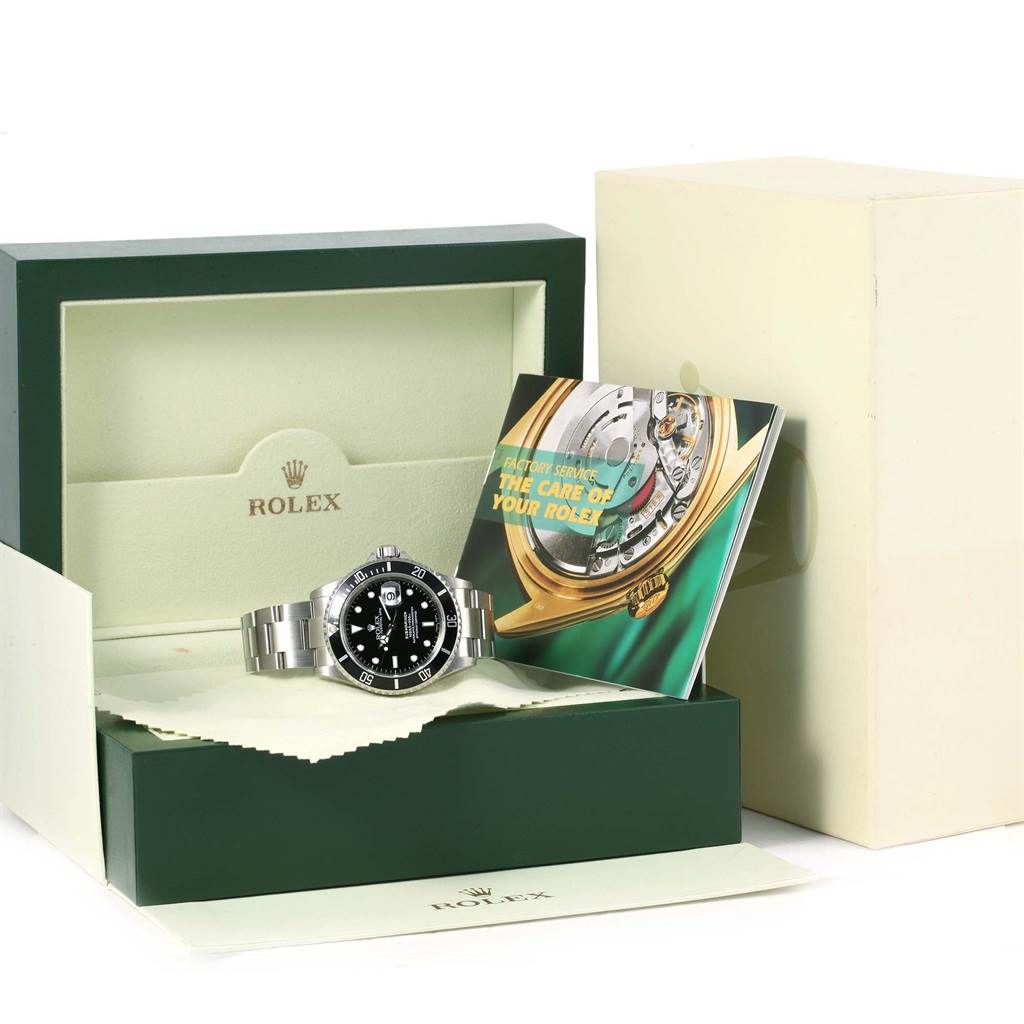 The image shows a Rolex Submariner 16610 Men
s Stainless Steel Black Dial 16610 Men
s Stainless Steel Black Dial watch at a slightly low angle in its box with accompanying booklets.