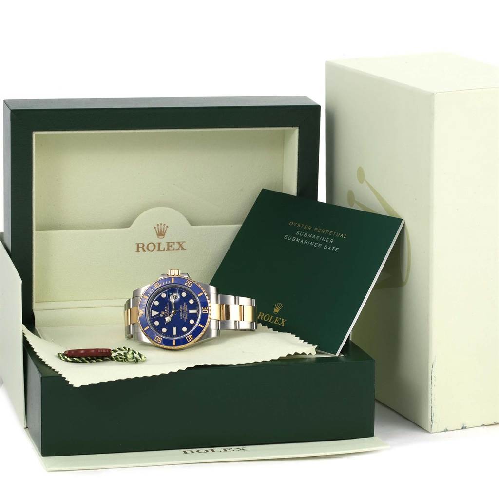 The image shows a Rolex Submariner 116613 Men
s Steel and Gold (two tone) Blue Dial 116613 Men
s Steel and Gold (two tone) Blue Dial watch with a blue dial and bezel, displayed in an open presentation box with accompanying documentation.