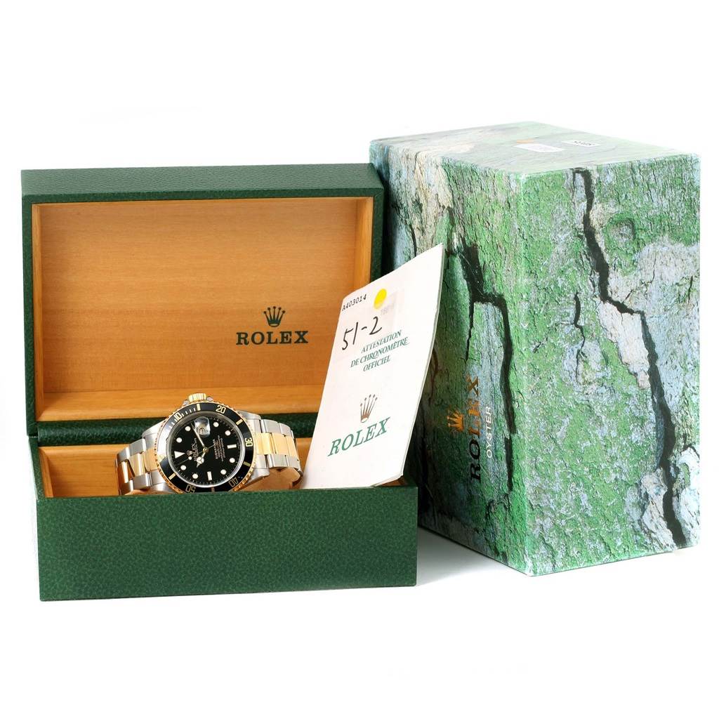 The image shows a Rolex Submariner 16613 Men's Steel and Gold (two tone) Black Dial 16613 Men's Steel and Gold (two tone) Black Dial watch in its open box, along with the packaging and an instruction booklet.