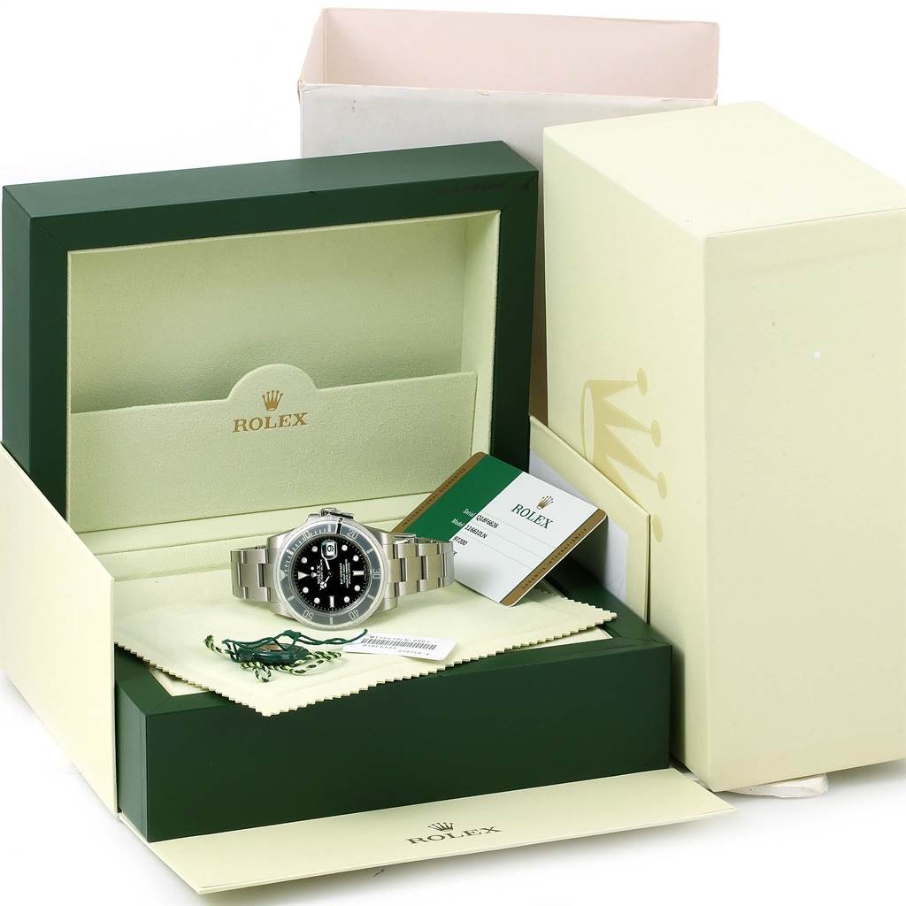 The image shows a Rolex Submariner 116610 Men
s Stainless Steel Black Dial 116610 Men
s Stainless Steel Black Dial watch in its open box, accompanied by tags, a cloth, and documentation.