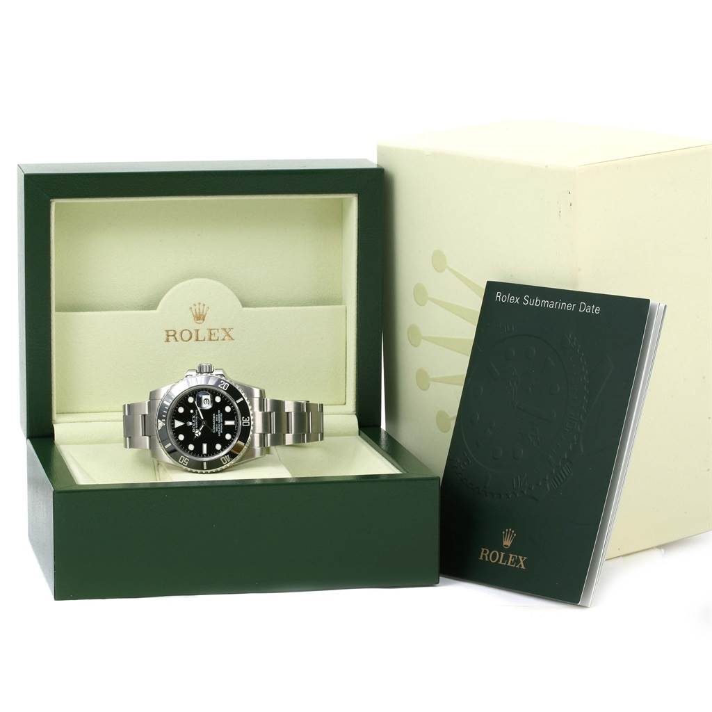 The image shows a Rolex Submariner 116610 Men's Stainless Steel Black Dial 116610 Men's Stainless Steel Black Dial watch laid in its open display box, with its manual beside the box.