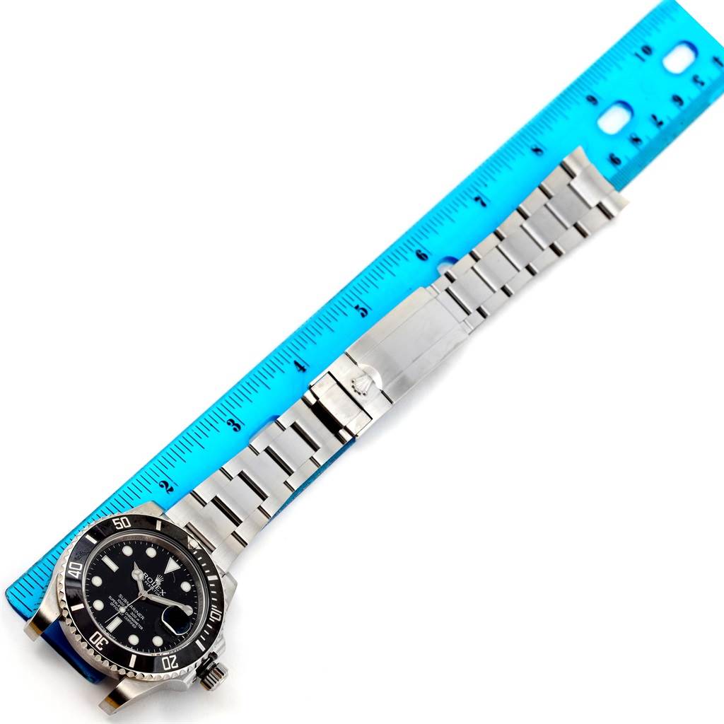 This image shows the entire Rolex Submariner 116610 Men's Stainless Steel Black Dial 116610 Men's Stainless Steel Black Dial watch, including its face, bezel, and bracelet, laid next to a blue ruler for scale.