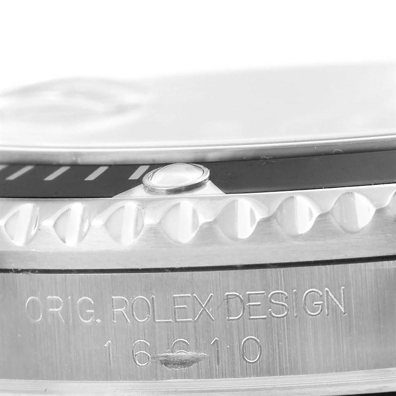 This macro shot of a Rolex Submariner shows the engraved side, focusing on the bezel and case edge.