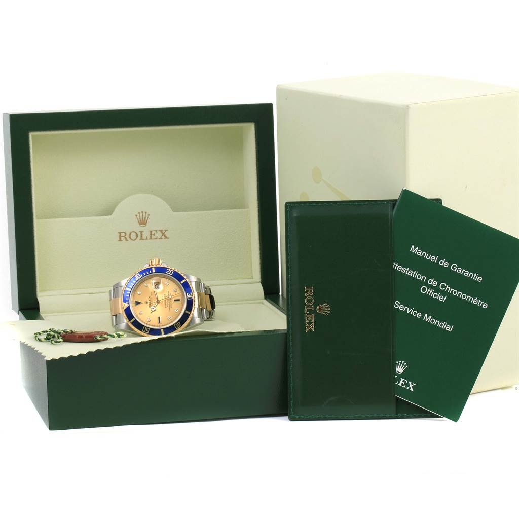 The image shows a Rolex Submariner 16613 Men's Steel and Gold (two tone) Champagne Dial 16613 Men's Steel and Gold (two tone) Champagne Dial watch, its open box, guarantee manual, and a larger outer box.