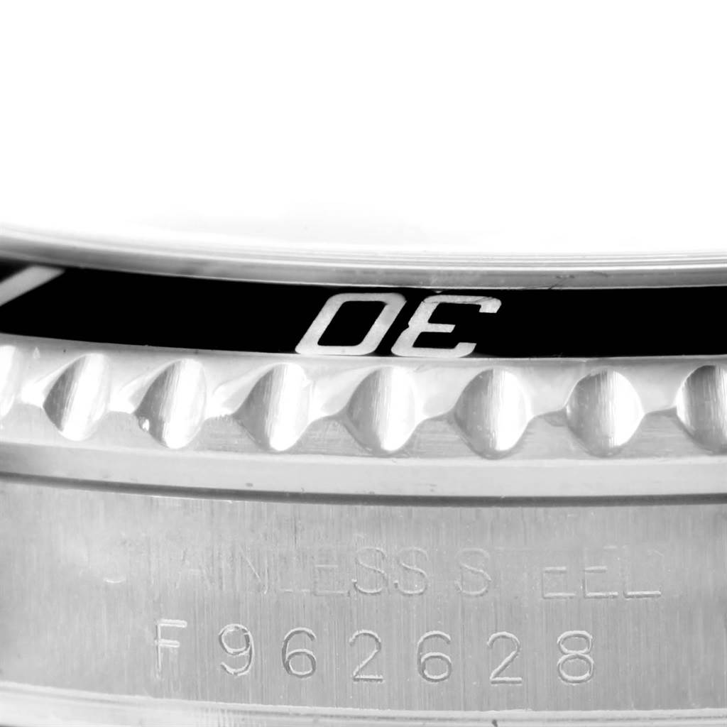 This is a close-up of the Rolex Submariner 16610 Men's Stainless Steel Black Dial 16610 Men's Stainless Steel Black Dial's bezel and serial number engraving.