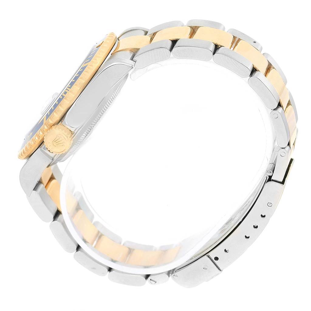 This side view image of the Rolex Submariner 16613 Men's Steel and Gold (two tone) Blue Dial 16613 Men's Steel and Gold (two tone) Blue Dial watch showcases the watch case, crown, and two-tone bracelet.
