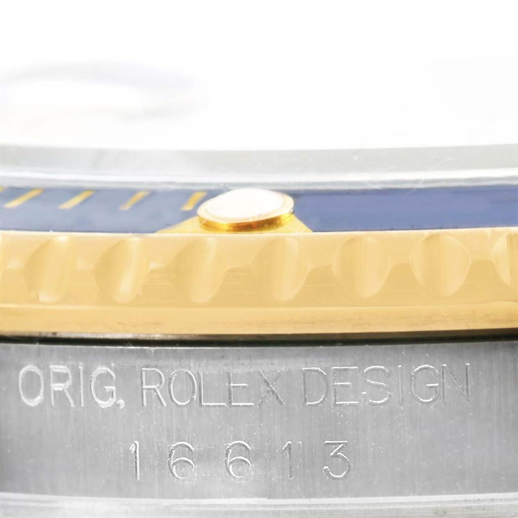 This image shows a close-up of the bezel and case side of the Rolex Submariner 16613 Men's Steel and Gold (two tone) Champagne Dial 16613 Men's Steel and Gold (two tone) Champagne Dial, highlighting the engraved text and model number.