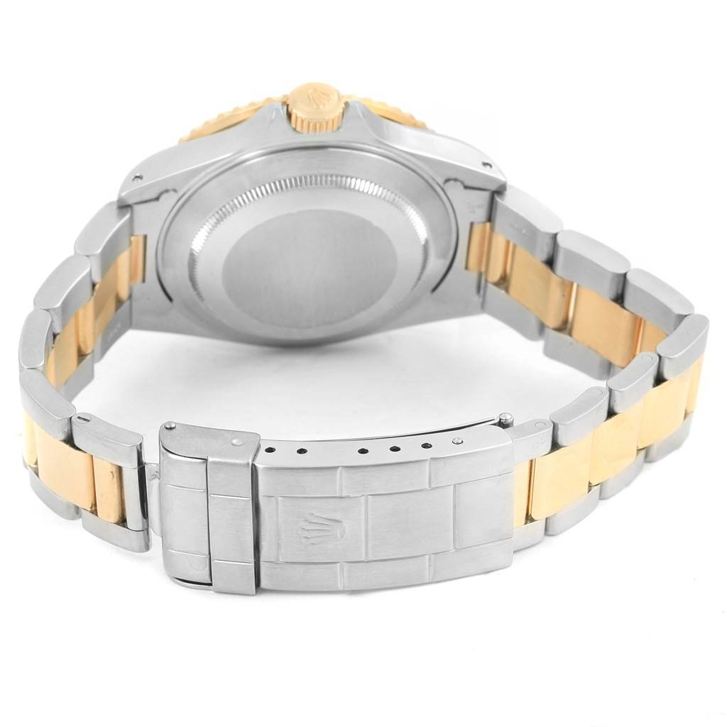 The image shows the back view of a Rolex Submariner 16613 Men's Steel and Gold (two tone) Champagne Dial 16613 Men's Steel and Gold (two tone) Champagne Dial, highlighting its case back, crown, and two-tone bracelet.