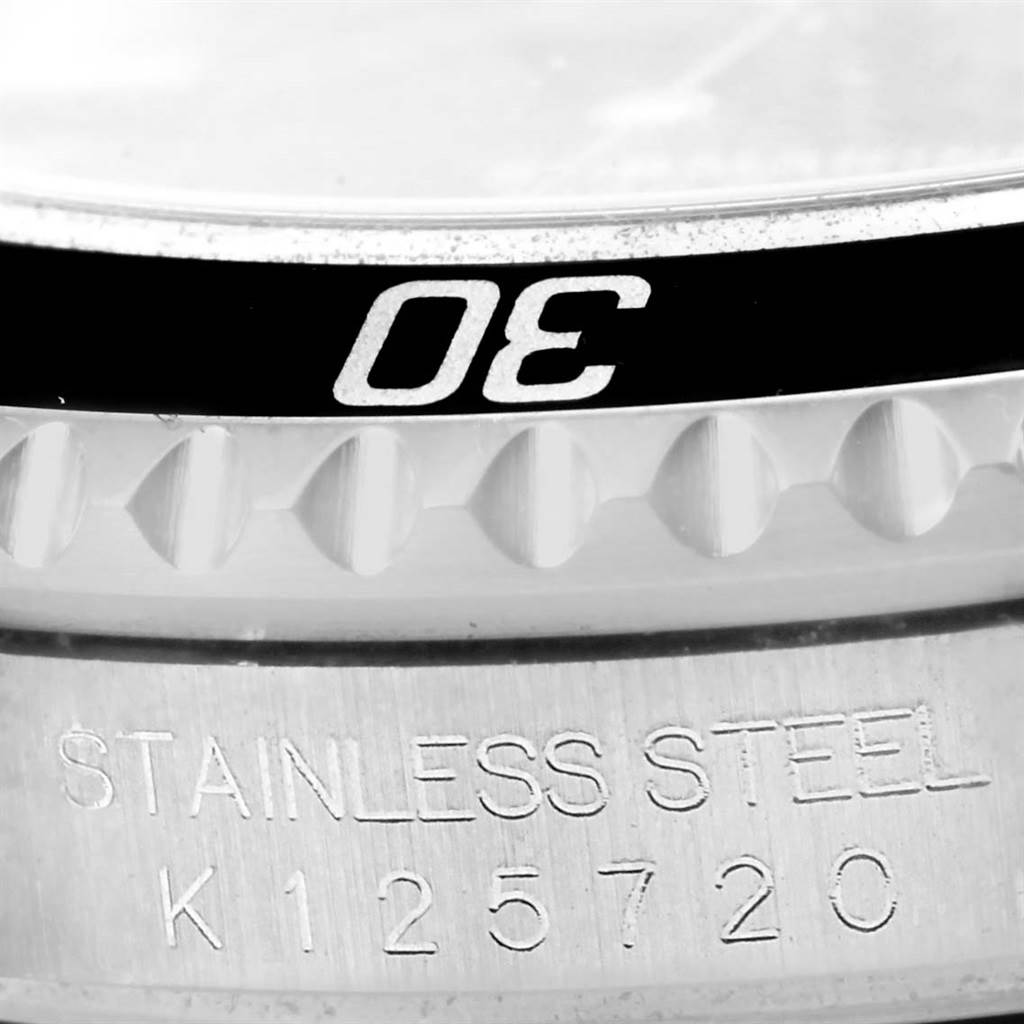 This image shows a close-up of the bezel and the engraved case back of a Rolex Submariner 16610 Men's Stainless Steel Black Dial 16610 Men's Stainless Steel Black Dial watch.