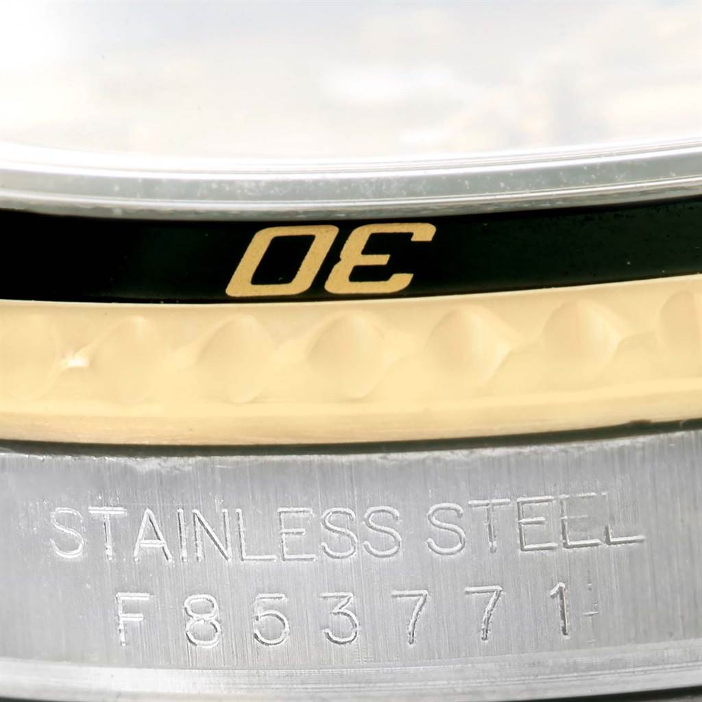 This close-up shows the bezel and case, including the serial number, of a Rolex Submariner 16613 Men's Steel and Gold (two tone) Champagne Dial 16613 Men's Steel and Gold (two tone) Champagne Dial watch.