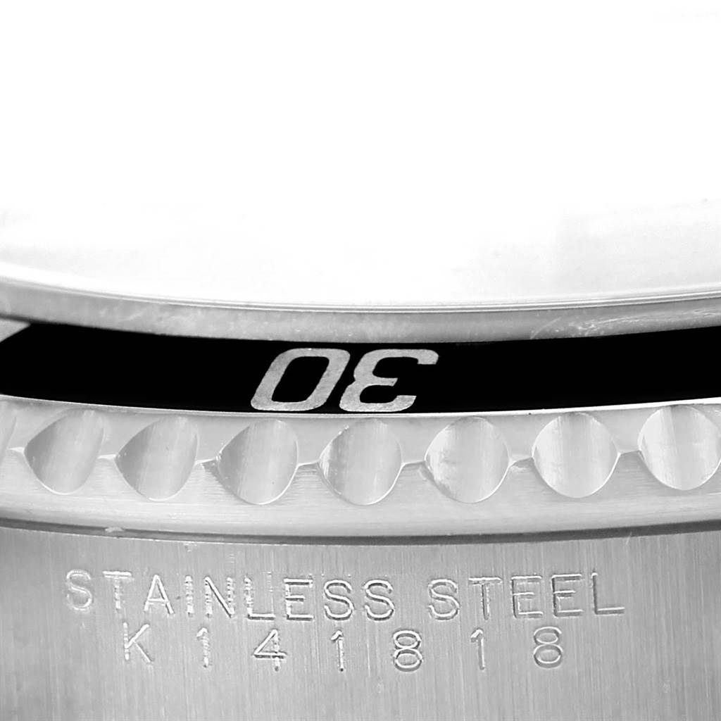This close-up image shows the bezel and engraved serial number on the stainless steel case of a Rolex Submariner 14060 Men's Stainless Steel Black Dial 14060 Men's Stainless Steel Black Dial watch.