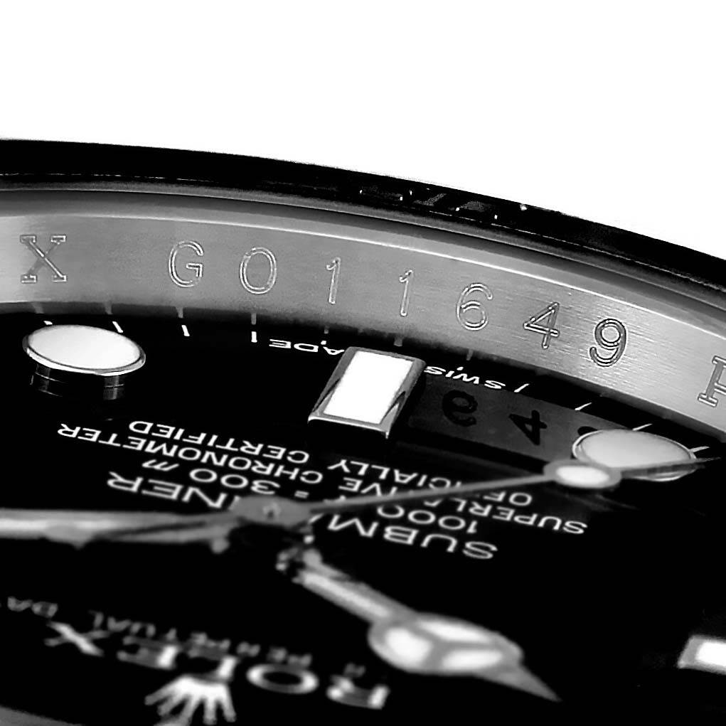 Close-up of a Rolex Submariner 116610 Men's Stainless Steel Black Dial 116610 Men's Stainless Steel Black Dial watch face, showing part of the dial, hands, and etched inner bezel.