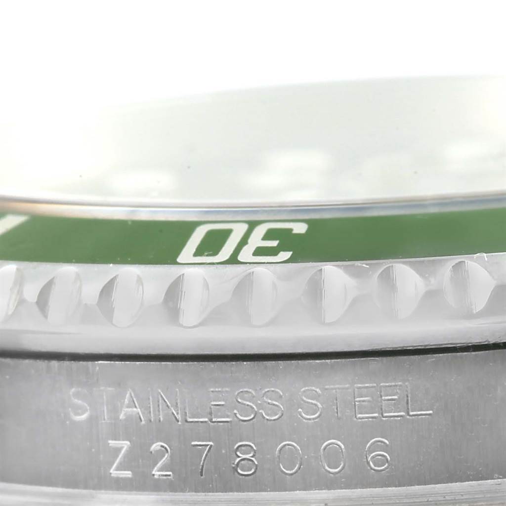 This close-up image of the Rolex Submariner 16610LV Men
s Stainless Steel Black Dial 16610LV Men
s Stainless Steel Black Dial watch shows part of the green bezel and stainless steel case with the serial number.