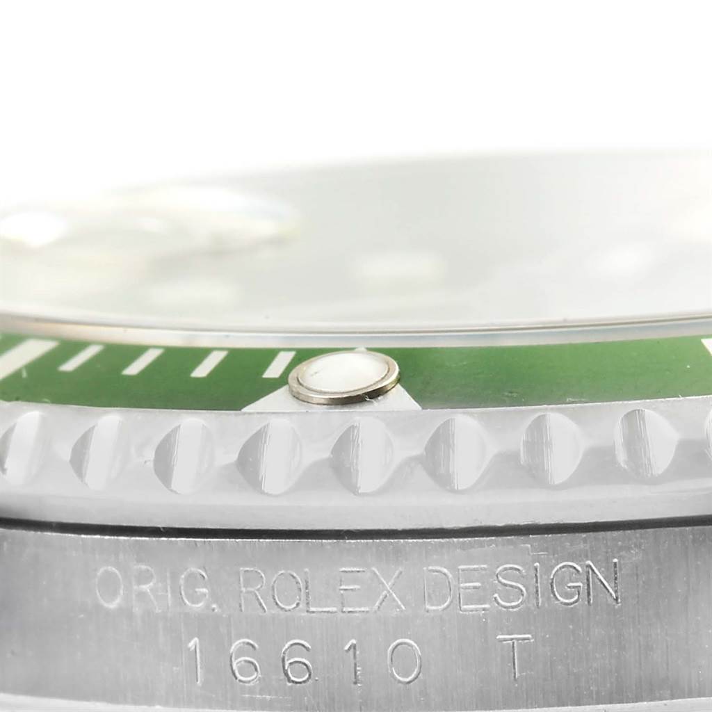 This image shows a close-up side angle of the bezel and part of the case of a Rolex Submariner 16610LV Men
s Stainless Steel Black Dial 16610LV Men
s Stainless Steel Black Dial watch, displaying the model number 16610T.
