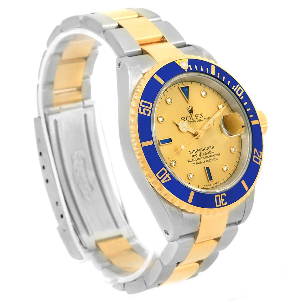 The image shows a Rolex Submariner 16613 Men
s Steel and Gold (two tone) Champagne Dial 16613 Men
s Steel and Gold (two tone) Champagne Dial watch with a gold and silver bracelet, blue bezel, and gold dial angled from the side/front.