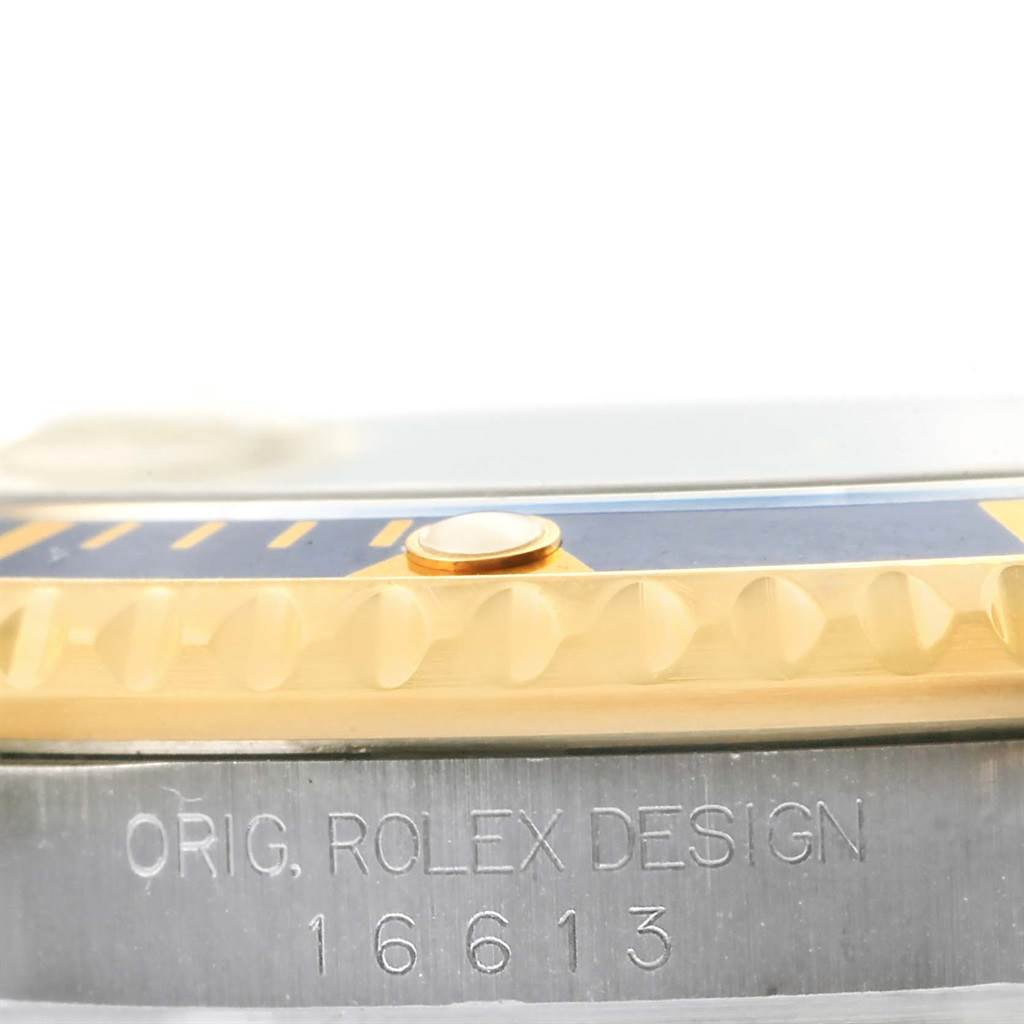 The image shows a close-up side view of the bezel and case of a Rolex Submariner 16613 Men
s Steel and Gold (two tone) Champagne Dial 16613 Men
s Steel and Gold (two tone) Champagne Dial, highlighting the engraving and partially visible bezel ring.
